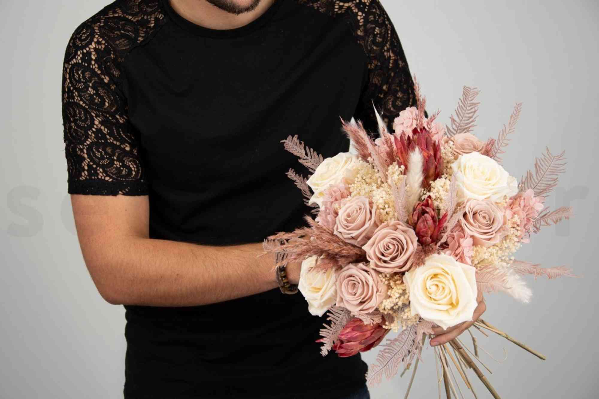 the wedding florist is holding the polished bouquet